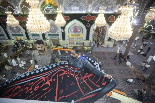 جمع آوری بیرق های عزا از حرم امام حسین(ع)